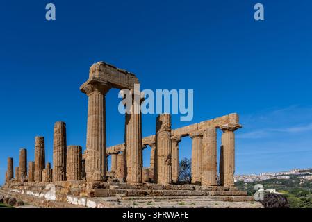 Panoramic view of the Doric Temple of Juno, also called Hera Lacinia, overlooking Agrigento and the Sicilian coast under a clear blue sky. Stock Photo