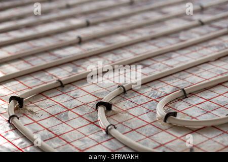 Modern underfloor heating installation with neatly arranged pipe loops, demonstrating efficient thermal distribution, plumbing engineering and home Stock Photo