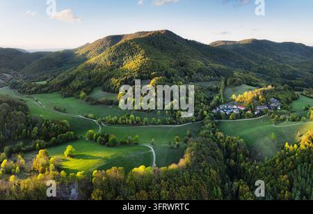 Scenic aerial view of a winding mountain by autumn forest colours and small village in Slovakia Stock Photo