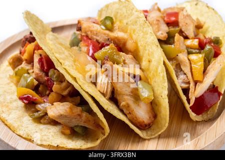 Crispy Mexican chicken tacos with colorful vegetables on white background Stock Photo