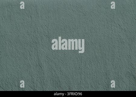 Close-up of dusty teal cotton fabric featuring a fine woven texture and muted blue green color. Stock Photo