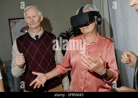 Senior Woman Using Virtual Reality Headset with Senior Man Stock Photo