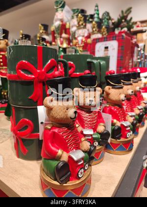 Christmas ornaments shaped like teddy bears with drums, toy cars,nutcracker soldiers and mugs displayed in astore before holidays Stock Photo