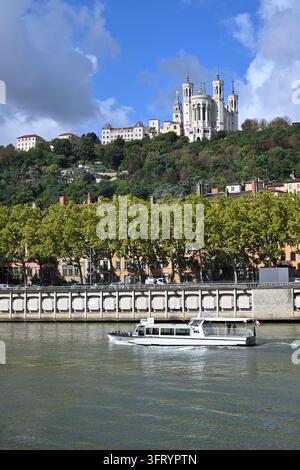 Lyon (south-eastern France): “Lui” river shuttle of the TCL “Navigône” service, on the Saône at the bottom of the Basilica of Notre-Dame de Fourvière Stock Photo