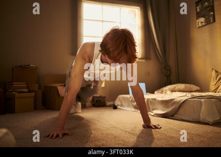 Man Doing Pushups on Floor during Morning Home Workout Stock Photo