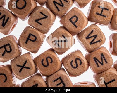 Top view texture of scattered wooden alphabet cubes with printed black letters Stock Photo