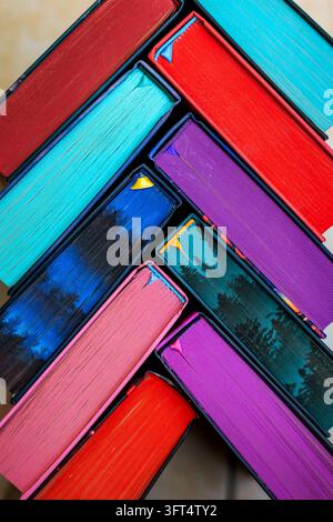 Close up of colorful book page edges arranged diagonally in a vibrant abstract geometric pattern, bright rainbow colors creating a creative background Stock Photo