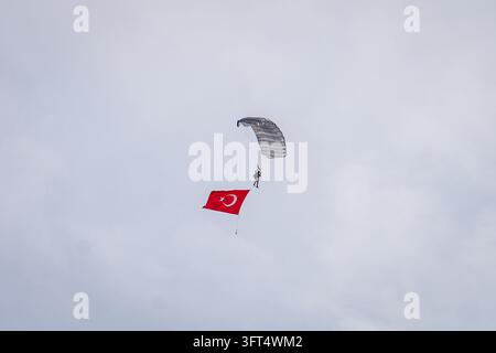 Turkey Rocket Ranges A military parachutist trails a large Turkish national flag while ...