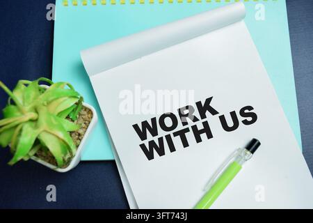 Concept of work with us write on book isolated on table. Stock Photo