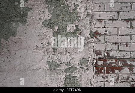 Weatherworn light pink wall with exposed porous concrete on the left and chipped red clay brick masonry on the right Stock Photo