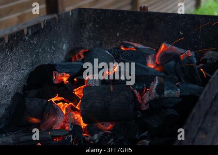 Burning glowing coals with orange ember in barbecue grill Stock Photo