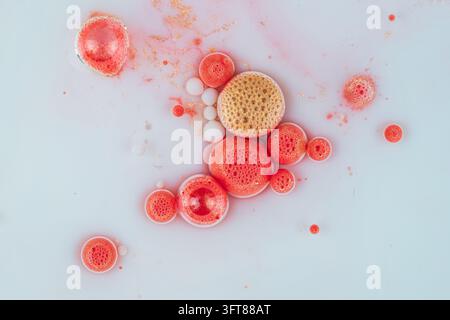 Liquid surface creating vibrant pink and golden bubbles. Abstract fluid art background, macro texture with circles Stock Photo