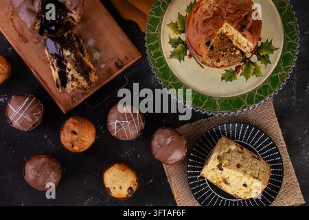 Flat lay composition featuring an assortment of traditional Italian Christmas sweet breads on a dark background. The arrangement includes a rich choco Stock Photo