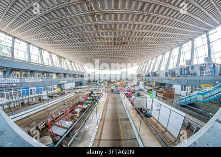 Industrial warehousemanufacturing facility in Kyiv, Ukraine Large windows allow natural light, casting shadows on gray-painted walls and concrete floo Stock Photo