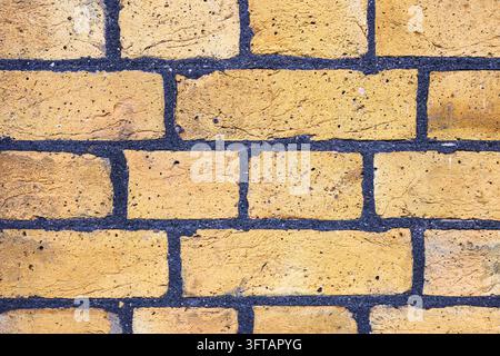 Background of yellow brick wall in close-up detail with contrasting grout Stock Photo
