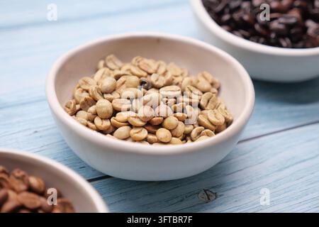 Different types of coffee beans are placed in small bowls on a table Stock Photo