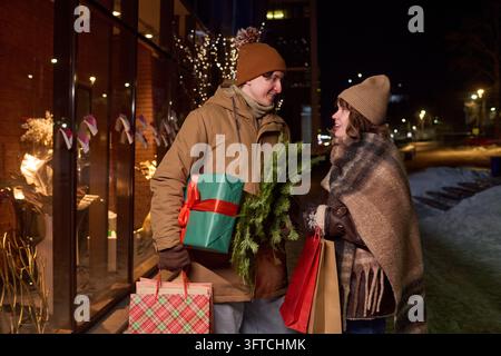 Couple Holding Shopping Bags and Gifts during Winter Holiday Season Stock Photo