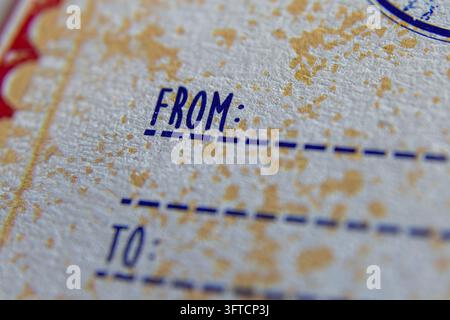A close-up macro shot of the hand-lettered style words "FROM" and "TO" with dashed lines, printed on a worn off-white paper. Stock Photo