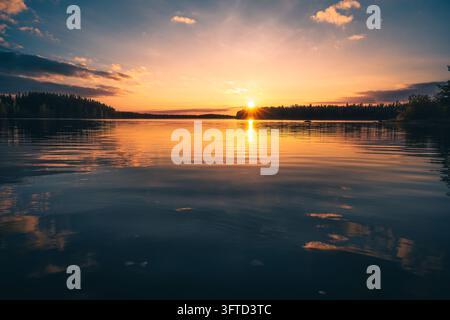 Golden Sunset Over a Forest Lake with Reflections on the Water Stock Photo