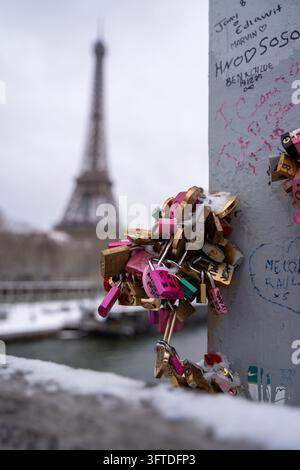 Love locks and graffiti on a footbridge with the Eiffel Tower blurred behind, Paris, France. Stock Photo