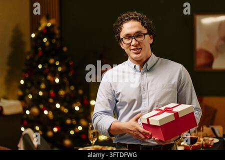 Portrait of Asian Man Holding Christmas Gift Box at Party Stock Photo