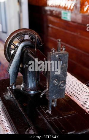 Close-up of vintage antique mechanical sewing machine with metal wheel and detailed craftmanship Stock Photo