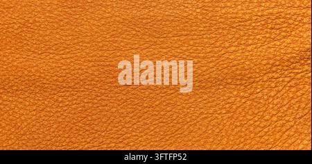 Close-up of a warm orange-yellow leather texture featuring a fine pebble grain pattern and a soft matte finish, offering a natural and rustic aestheti Stock Photo