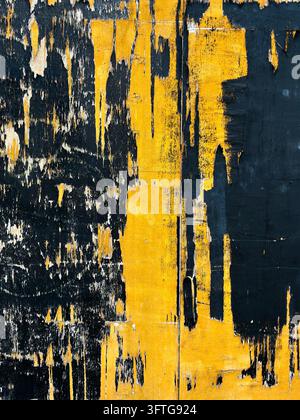 Peeling and cracked orange, and black paint on a hoarding surrounding a building site, London, UK Stock Photo