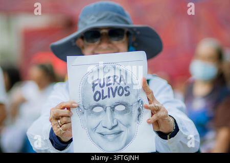 A protester holds a protest sign reading 