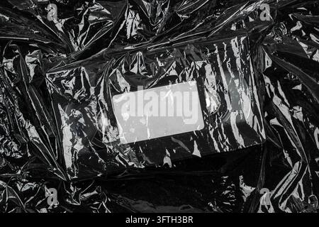 Retro VHS cassette wrapped in crumpled black plastic film. Stock Photo