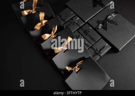 Black Friday. Black gift bags and boxes with golden ribbons Stock Photo