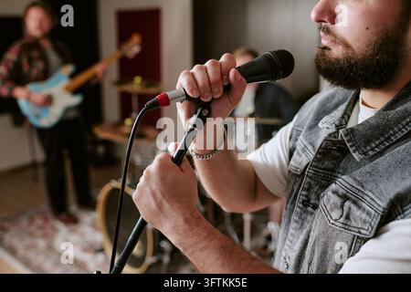 Male Singer Rehearsing with Rock Band in Studio Stock Photo