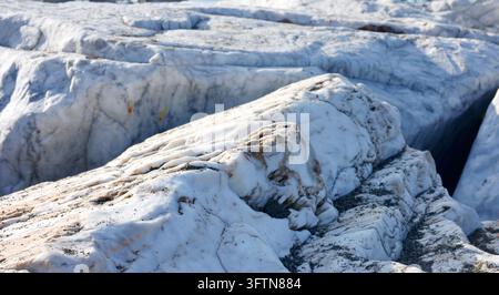 Natural white marble rock texture geological background raw stone surface. Fractured metamorphic mineral formation rough coastal outcrop patterns Stock Photo