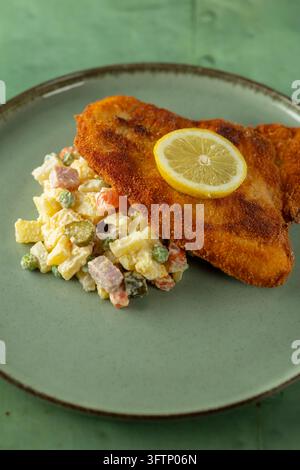 Crispy fried schnitzel served on a plate with traditional potato salad Stock Photo