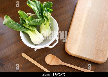 Fresh bok choy in colander wooden cutting board copy space. Clean eating healthy nutrition plant based organic diet concept. Culinary blog recipe prep Stock Photo