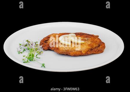 Breaded cutlet served with lemon and fresh sprouts Stock Photo
