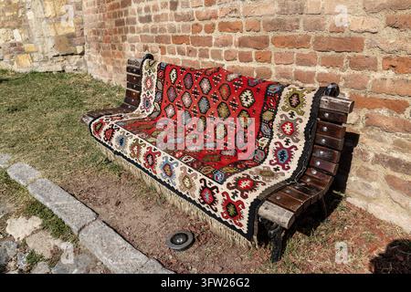 BELGRADE, SERBIA - SEPTEMBER 29, 2026: A traditional Pirot kilim (Pirotski cilim) with traditional motifs, spread over a wooden bench in Kalemegdan Pa Stock Photo