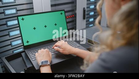 Female IT Specialist Works on Green Screen Laptop Inside Modern Data Center, Offering Customizable Footage for Women in Technology, Cybersecurity, Cloud Infrastructure and Digital Interface Concepts. Stock Photo