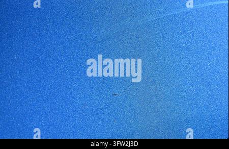 A detailed horizontal stock photograph showcasing an extreme close-up of a blue metallic car paint texture with sparkling particles and smooth finish. Stock Photo