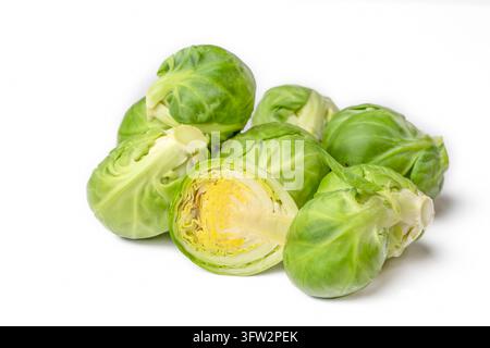 Fresh green brussels sprouts heap with one cut in half isolated on white background Stock Photo