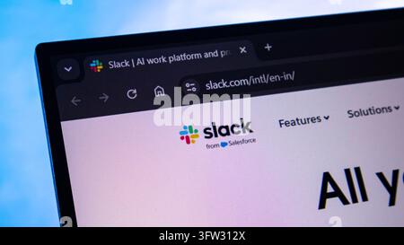 A laptop displays the Slack website, with its logo and navigation visible in the browser Stock Photo