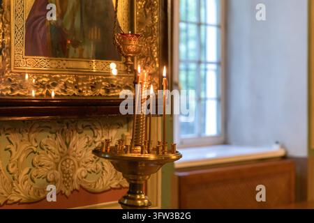 Orthodox Church. Christianity. Festive interior decoration with burning candles and icon in traditional Orthodox Church on Easter Eve or Christmas. Religion faith pray symbol Stock Photo