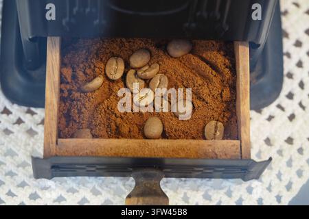 Coffee beans and ground coffee in a grinder drawer during preparation Stock Photo