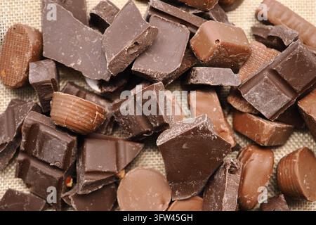 Assorted chocolate pieces scattered on a woven surface Stock Photo