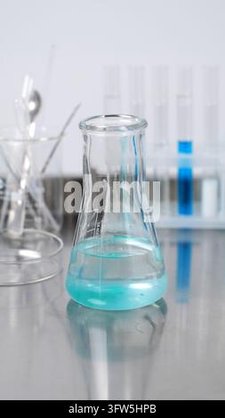 Erlenmeyer flask with turquoise liquid in a chemistry laboratory, conducting a scientific experiment or research Stock Photo