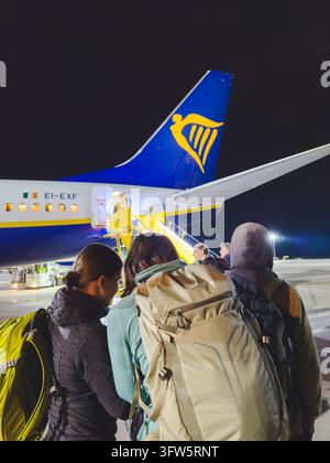 Vienna, Austria, October 10, 2026. Passengers carrying backpacks wait to board a Ryanair aircraft through the rear boarding stairs on the apron at Vie Stock Photo
