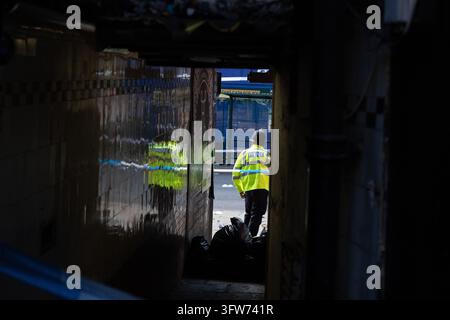 A police officer seen down an alley way in a crime scene after a Police ...