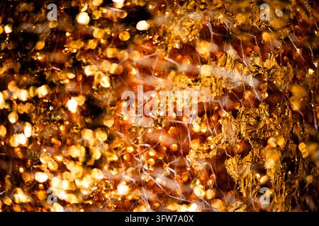 Golden foil background in glossy pattern. Golden sparkling surface for luxury design. Golden futuristic texture on metallic wallpaper. Golden elegant Stock Photo