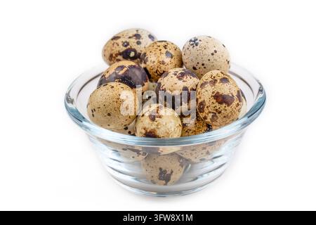 Fresh speckled quail eggs in a clear glass bowl isolated on white background Stock Photo