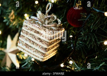 Glittering Christmas Gift Ornament Hangs on Festive Tree Stock Photo